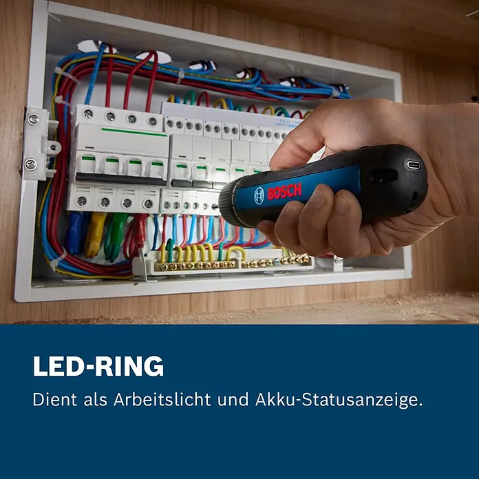 Bosch Professional Akkuschrauber Go - 3,6 V, 1 Akku, 5 Nm - Eine Hand hält ein schwarz-blaues Bosch-Werkzeug mit LED-Ring, das einen Schaltkasten beleuchtet. Der LED-Ring dient als Arbeitslicht und Akku-Statusanzeige.