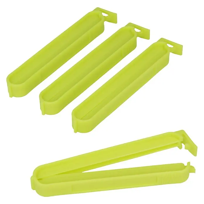 Metaltex Clips - 4 Stk., L x B x H: 11 x 1,2 x 1,5 cm - Nahaufnahme von vier gelb-grünen Clip-Verschlüssen für Tüten, drei davon geschlossen und einer geöffnet, ideal zum Frischhalten von Lebensmitteln.