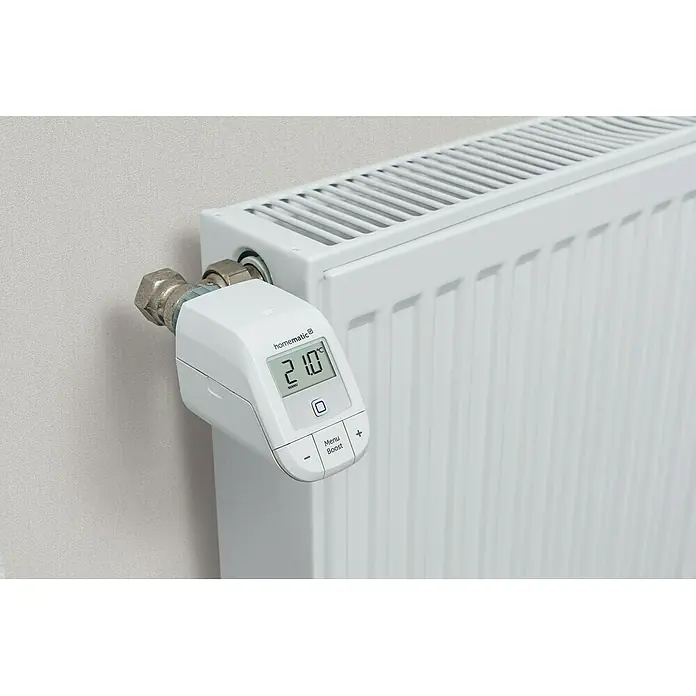 Homematic IP Starter-Set Heizen Easy Connect - 1 x Heizkörperthermostat, 1 x Fenster- und Türkontakt, 1 x Adapter Danfoss RA, 1 x Stützring, 1 x Montagematerial, 4 x Batterien, 1 x Bedienungsanleitung - Nahaufnahme eines Homematic Heizkörperthermostats mit digitaler Anzeige, das an einem weißen Heizkörper montiert ist.