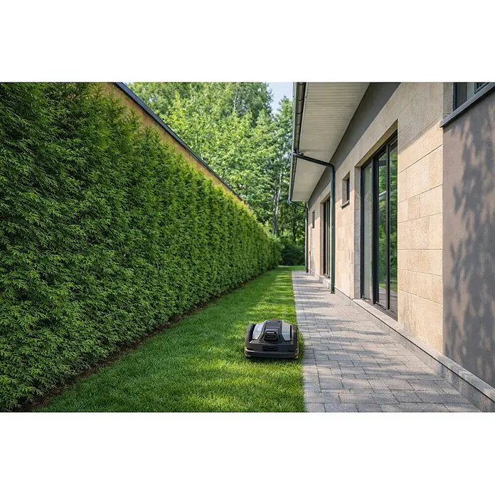 Greenworks Mähroboter AI Mowbot 10 GW KI RTK+VISION - 1.000 m², Schnittbreite: 20 cm, Satellitengestützte Navigation, RTK - Ein grauer und schwarzer Rasenroboter steht auf einem grünen Rasen neben einem gepflasterten Weg und einer hohen Hecke.