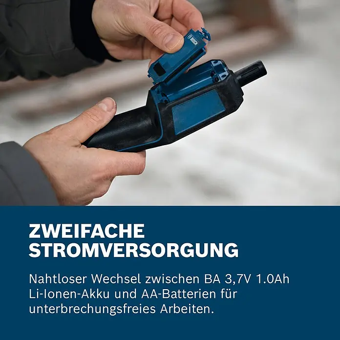 Bosch Thermo-Hygrometer GDH 1-17 - Mit Batterien - Hände stecken einen blauen Bosch Li-Ion-Akku in ein schwarz-blaues Werkzeug, das die Dual-Stromversorgung zeigt.