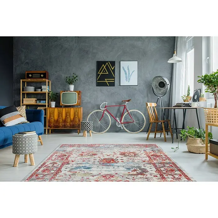Kayoom Kurzflorteppich Antigua II - Bunt, 170 x 120 cm, 100 % Polyester - Ein Vintage-Wohnzimmer mit einem auffälligen Teppich in Rot-, Blau- und Grautönen, der dem Raum Charakter verleiht.