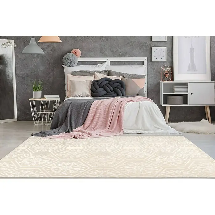 Kayoom Kurzflorteppich Monroe II - Creme, 300 x 80 cm, 100 % Polyester - Ein beigefarbener Teppich mit einem geometrischen Muster liegt in einem Schlafzimmer unter einem Bett mit rosa und grauen Decken.