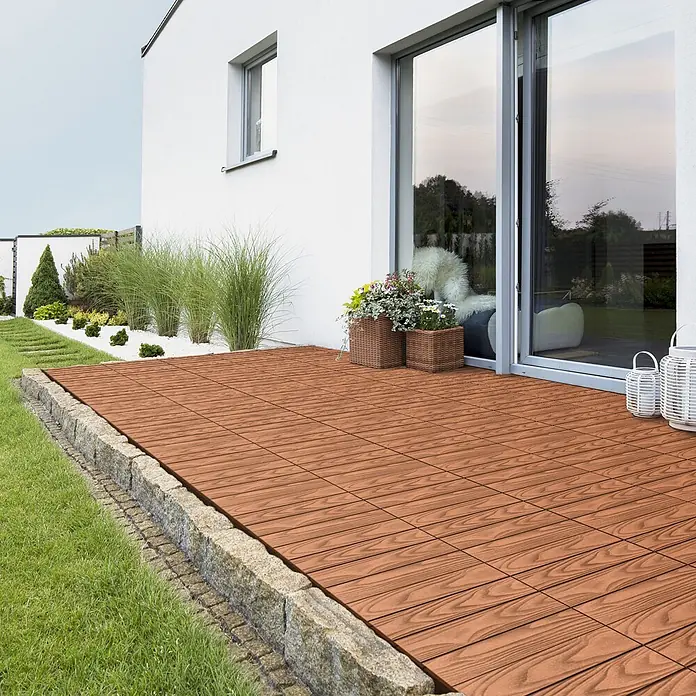ML-Design Terrassenfliese Bodenbelag 5m²/55 Stück Hellbraun rutschfest Balkonfliesen - 30 cm x 30 cm x 20 mm, Hellbraun - Rötlich-braune Holzoptik-Terrassenfliesen bilden eine Außenterrasse neben einem Haus, begrenzt von Naturstein.