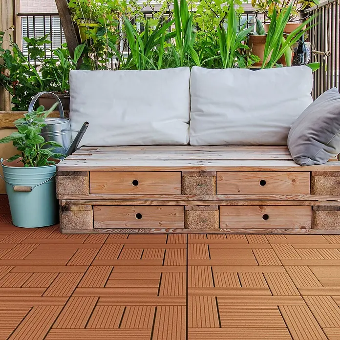 ECD Germany Terrassenfliese Bodenbelag 3m²/33 Stück Hellbraun rutschfest Balkonfliesen - 30 cm x 30 cm x 20 mm, Hellbraun - Handgefertigtes Holzpalettensofa mit weißen Kissen und einem grauen Polster auf einem Balkon mit Terrakotta-Klickfliesen und Pflanzen.