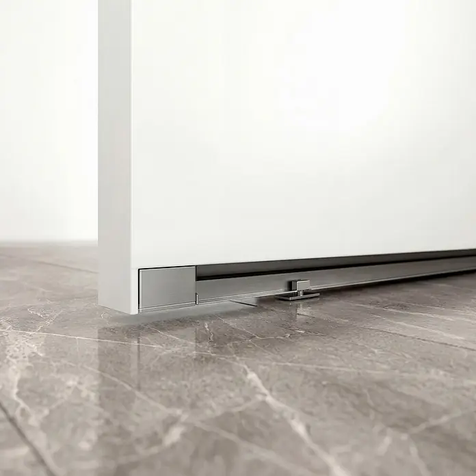 Entravia Schiebetür-Komplettset CleanSlide - 1.067 x 2.200 mm, Verkehrsweiß, Röhrenspan - Weiße Schiebetür mit gebürsteter Metall-Bodenführung und bodenmontiertem Stopper auf Marmorboden.