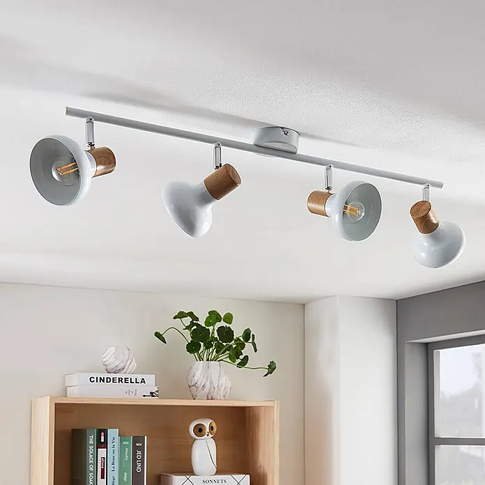 Lindby Deckenstrahler Fridolin - weiß / opal, weiß / opal, E14 - Deckenstrahler mit vier weißen Spotlights und Holzdetails, an der Decke über einem Regal montiert.