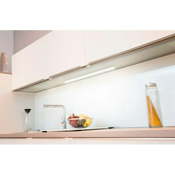 Müller-Licht LED-Unterbauleuchte Conero - L x B x H: 90,9 x 5,3 x 2,9 cm, Lichtfarbe: Neutralweiß, 15 W, Weiß - Eine moderne Küche mit LED-Unterbauleuchten, die die Arbeitsfläche beleuchten, zusammen mit einer Obstschale und einer Spaghettidose.