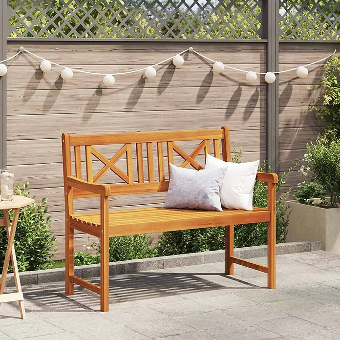 Furnicato Gartenbank Akazien-Massivholz geölt - B x T x H: 56 x 110 x 90 cm, Massivholz Akazie, Braun - Hölzerne Gartenbank mit X-förmiger Rückenlehne und Armlehnen, verziert mit zwei Kissen, auf einer Terrasse.