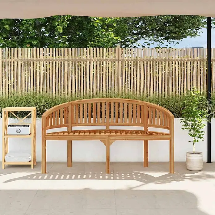 Furnicato Gartenbank Teak-Hartholz - B x T x H: 60 x 151 x 86 cm, Braun - Gekrümmte hellbraune Gartenbank aus Holz auf einer Terrasse.
