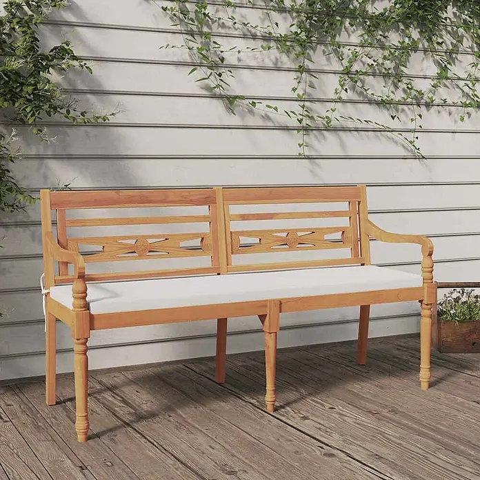 Furnicato Gartenbank Teakholz geölt - B x T x H: 150 x 51,5 x 84 cm, Weiß - Holzgartenbank mit kunstvollem Rückendesign und weißem Kissen auf einer Holzterrasse.