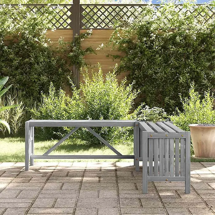 Furnicato Gartenbank Akazien-Massivholz - B x T x H: 117 x 117 x 40 cm, Grau - Grau lackierte L-förmige Gartenbank aus Holz mit integriertem Beistelltisch auf einer Terrasse.