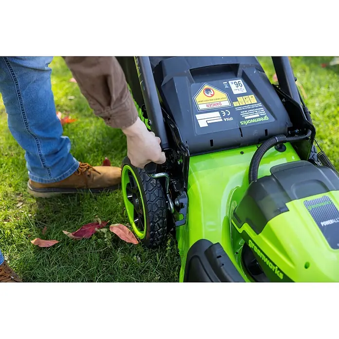 Greenworks Akku-Rasenmäher GW 2X24V BL 46 cm - 24 V, Ohne Akku, Schnittbreite: 46 cm - Person stellt die Schnitthöhe eines hellgrünen Greenworks Rasenmähers ein.