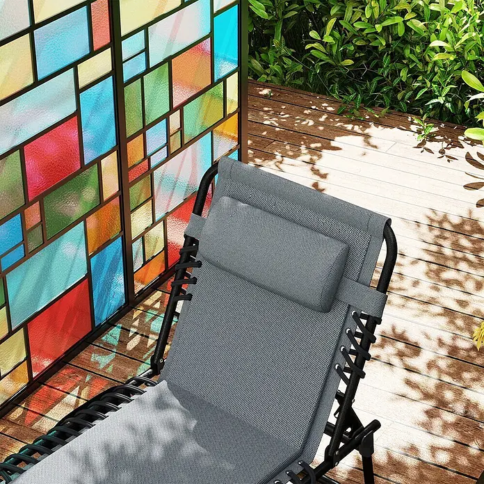 Furnicato Gartenliege - Dunkelgrau, Polyester - Grauer Mesh-Liegestuhl mit Kopfkissen auf einer Holzterrasse für entspannte Stunden im Freien.