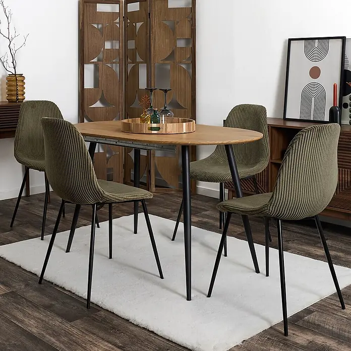 Home Deco Factory Silla Scott - Verde, 4 ud. - Una mesa de comedor ovalada de madera con patas negras, rodeada de cuatro sillas de tela acanalada verde oliva con patas negras, sobre una alfombra blanca.