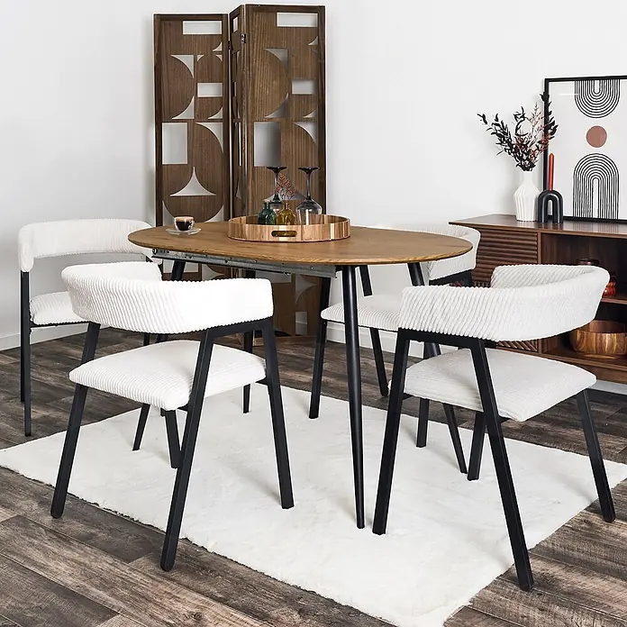 Home Deco Factory Silla Scott - Beige, 2 ud. - Mesa de comedor ovalada de madera con patas negras y cuatro sillas blancas acanaladas con estructuras negras, sobre una alfombra blanca.