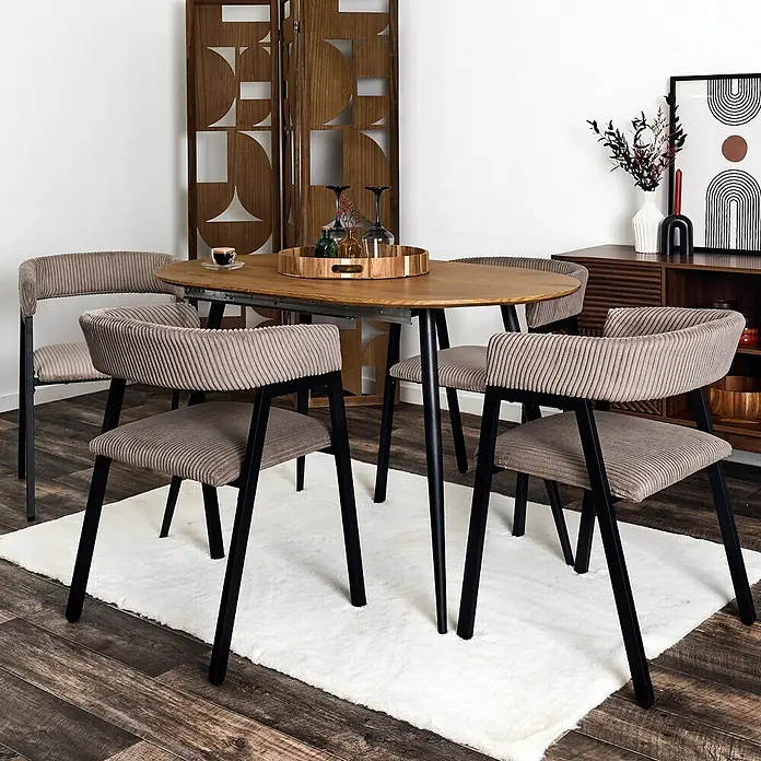 Home Deco Factory Silla Scott - Taupe, 2 ud. - Mesa de comedor ovalada de madera con patas negras y cuatro sillas de pana beige, sobre una alfombra blanca en un comedor.