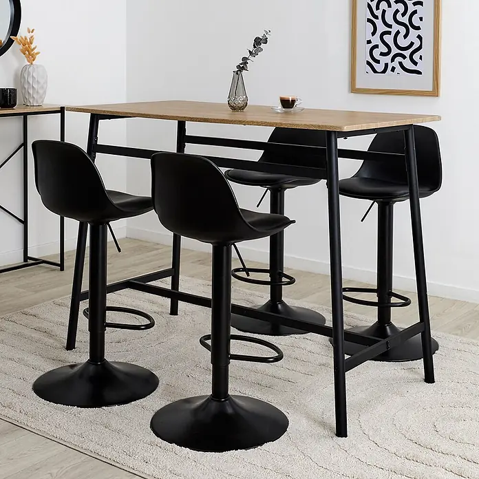 Home Deco Factory Loka Mesa de comedor - L x An x Al: 116 x 60 x 90 cm, Negro/Marrón, Metal/MDF - Mesa de bar con tablero de madera clara y estructura de metal negro, acompañada de cuatro taburetes de bar negros, sobre una alfombra clara.