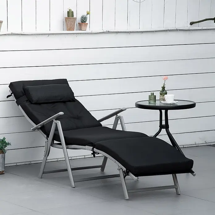 Furnicato Gartenliege - B x T: 63,5 x 178 cm, Schwarz, Metall - Eine schwarz gepolsterte Klappliege mit silberfarbenem Gestell steht auf einer Terrasse neben einem kleinen runden Tisch.
