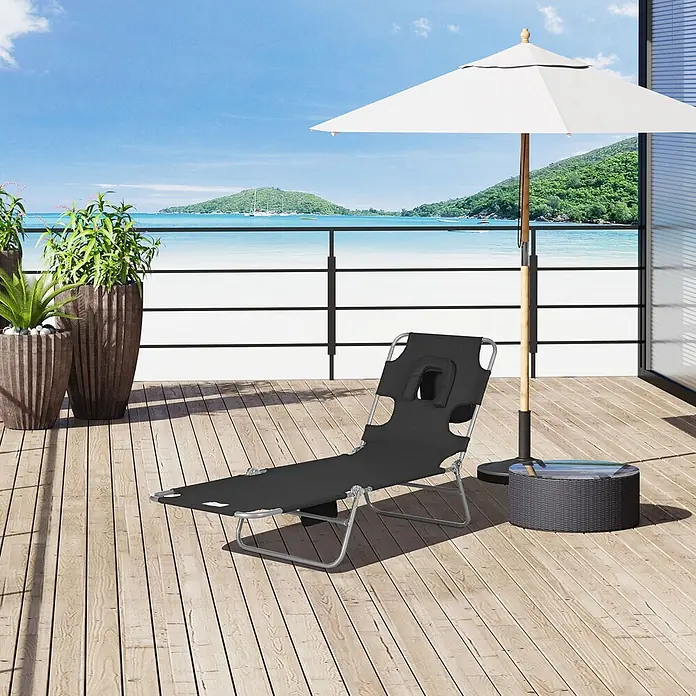 Outsunny Gartenliege - B x T: 55 x 185 cm, Schwarz, Polyester, Klappbar - Schwarze klappbare Strandliege mit Kopfstütze zum Bauchreclinen, auf einer Holzterrasse am Meer.