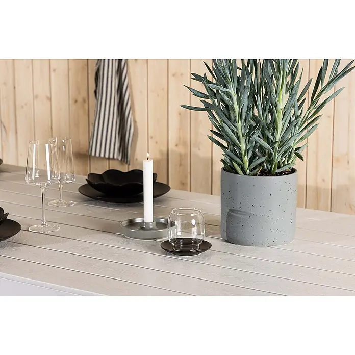 Ebuy24 Gartentisch Break - L x B x H: 205 x 90 x 75 cm, Ø x H: 90 x 75 cm, Aluminium, Weiß - Moderne Tischdekoration mit hellgrauem Tisch, schwarzen Tellern, Weingläsern, brennender Kerze und grüner Pflanze in grauem Topf.