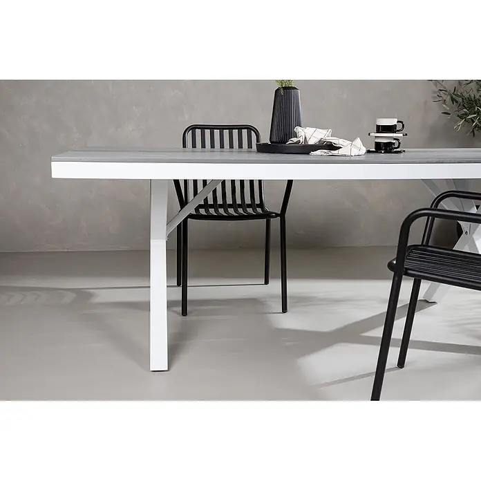 Ebuy24 Gartentisch Garcia - L x B x H: 200 x 100 x 74 cm, Ø x H: 100 x 74 cm, Nonwood, Aluminum, Grau - Moderner Esstisch mit grauer Platte und weißen Beinen, umgeben von schwarzen Stühlen.