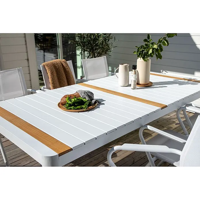 Ebuy24 Gartentisch Togo - L x B x H: 200 x 100 x 75 cm, Ø x H: 100 x 75 cm, Aluminium, Sonstige, Weiß - Weißer Gartentisch mit Holzakzenten und Stühlen, auf einer Terrasse für eine Mahlzeit gedeckt.
