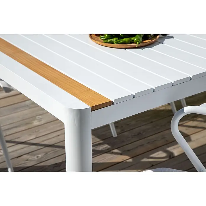 Ebuy24 Gartentisch Togo - L x B x H: 200 x 100 x 75 cm, Ø x H: 100 x 75 cm, Aluminium, Sonstige, Weiß - Weißer Lamellen-Gartentisch mit Holzeinlage, auf einer Terrasse mit einer Schale Paprika.