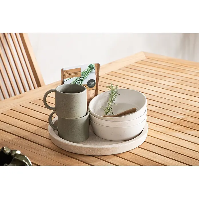 Ebuy24 Gartentisch Panama - L x B x H: 324 x 100 x 75 cm, Ø x H: 100 x 75 cm, Aluminium, Teak, Sonstige, Weiß - Zwei gesprenkelte Steinguttassen und drei Schalen auf einem passenden Tablett, daneben eine Schnittlauch-Samenpackung und ein Rosmarinzweig, auf Holztisch.