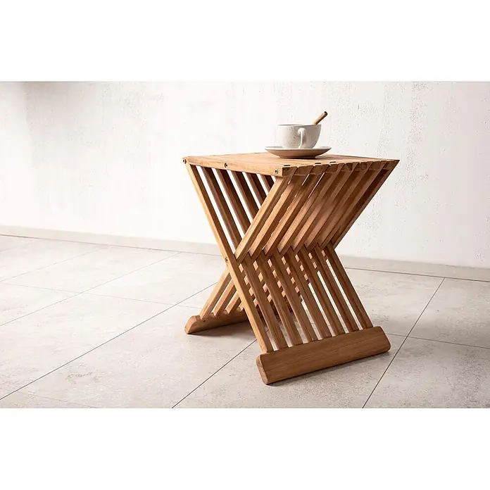 Ebuy24 Gartentisch Ghana - L x B x H: 39 x 37 x 43 cm, Ø x H: 37 x 43 cm, Teak, Sonstige, Teak Dekor - Holzlamellen-Beistelltisch mit X-förmigem Fuß, auf dem eine Keramiktasse und Untertasse stehen.