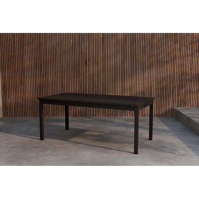 Ebuy24 Gartentisch Kenya - L x B x H: 180 x 90 x 75 cm, Ø x H: 90 x 75 cm, Teak, Schwarz - Ein dunkelbrauner rechteckiger Esstisch steht auf einer Betonterrasse vor einer Holzlamellenwand.