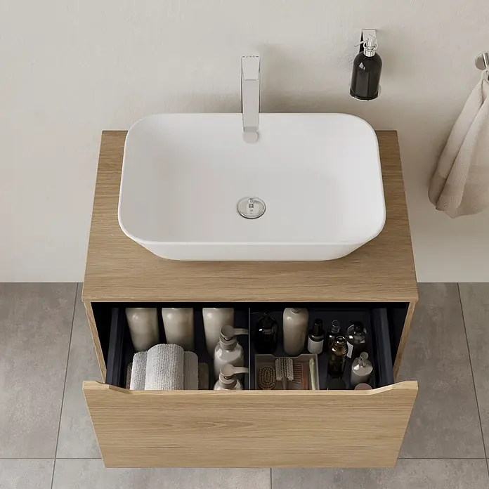 VitrA Integra Square Waschtischunterschrank Integra Square - B x T x H: 80 x 52 x 42 cm, Eiche Gold - Weißes, rechteckiges Waschbecken auf einem hellen Holzwaschtisch mit geöffneter Schublade, die organisierte Toilettenartikel zeigt.
