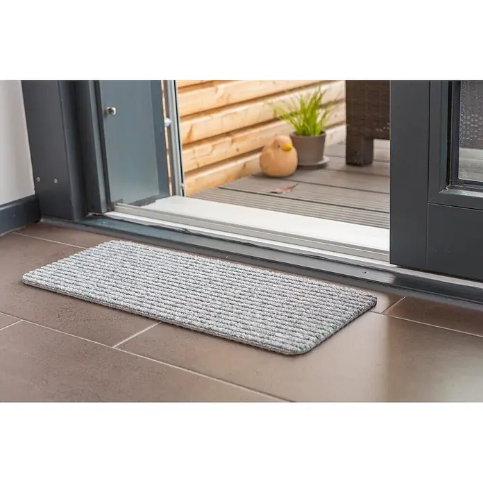 Fußmatte Rib Line Mini Sprint - 60 x 25 cm, Silber, Material Nutzschicht: 75 % Polypropylen, 25 % Polyester - Hellgraue gerippte Fußmatte auf braunen Fliesen, vor einer Schiebetür platziert.