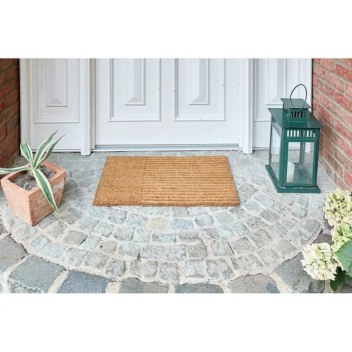 Fußmatte Coco Shape - 75 x 45 cm, Natur, Material Nutzschicht: 100 % Kokos, Streifen - Naturfarbene Kokos-Fußmatte mit zweifarbiger Textur, auf einem gepflasterten Eingang vor einer weißen Tür.