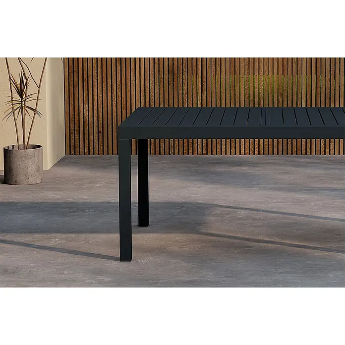 Ebuy24 Gartentisch Capo - L x B x H: 160 x 100 x 75 cm, Ø x H: 100 x 75 cm, Aluminium, Sonstige, Schwarz - Dunkelgrauer Lamellen-Esstisch für draußen mit quadratischen Beinen, auf einer Terrasse platziert.