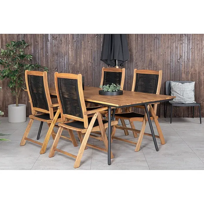 Ebuy24 Gartentisch Chan - L x B x H: 200 x 100 x 74 cm, Ø x H: 100 x 74 cm, Akazie, Stahl, Sonstige, Teak Dekor - Gartensitzgruppe aus Holz mit Tisch und vier Stühlen mit schwarzen geflochtenen Lehnen und Sitzen, auf einer Terrasse.