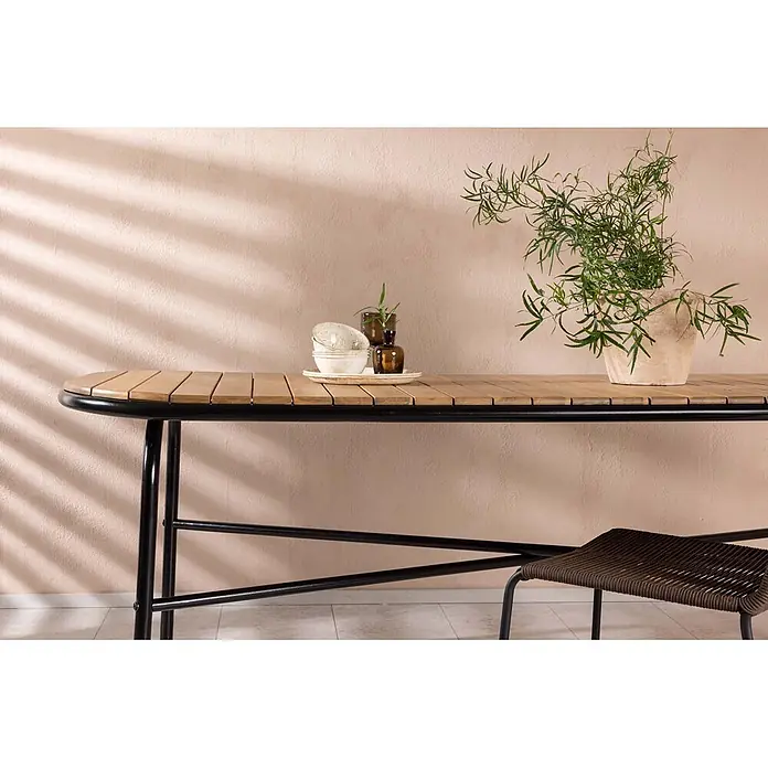 Ebuy24 Gartentisch Holmbeck - L x B x H: 200 x 90 x 75 cm, Ø x H: 90 x 75 cm, Akazie, Natur - Rechteckiger Esstisch aus Holz mit schwarzem Metallgestell, dekoriert mit Geschirr und Pflanze.