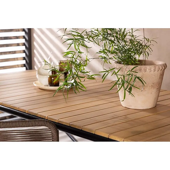 Ebuy24 Gartentisch Holmbeck - L x B x H: 200 x 90 x 75 cm, Ø x H: 90 x 75 cm, Akazie, Natur - Gartentisch mit heller Holzlattenplatte und dunklem Gestell, kombiniert mit einem braunen Rattanstuhl.