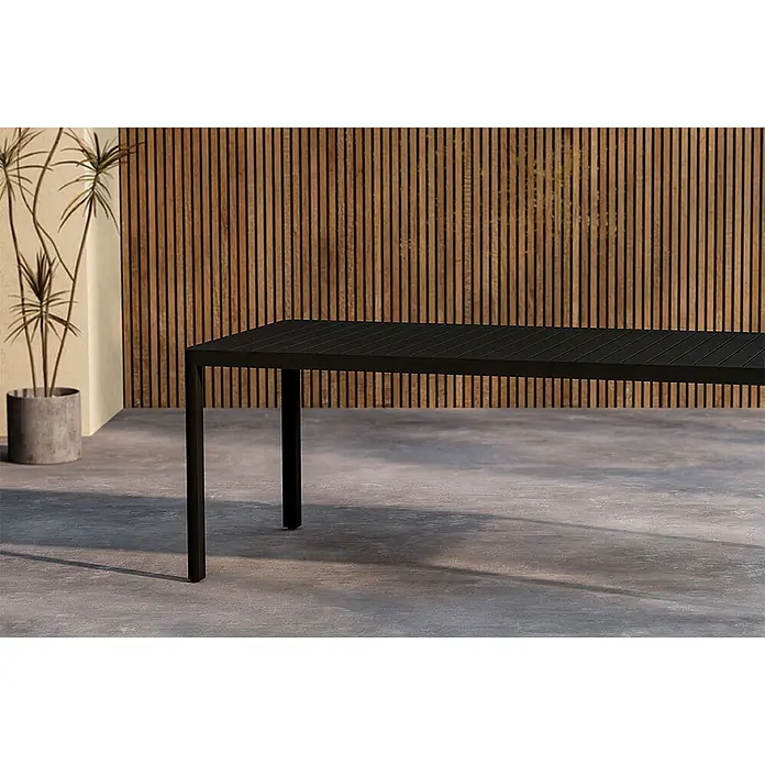 Ebuy24 Gartentisch Giardini - L x B x H: 200 x 90 x 72 cm, Ø x H: 90 x 72 cm, Aluminium, Schwarz - Schwarzer Lamellen-Esstisch für den Außenbereich auf einer Betonterrasse.