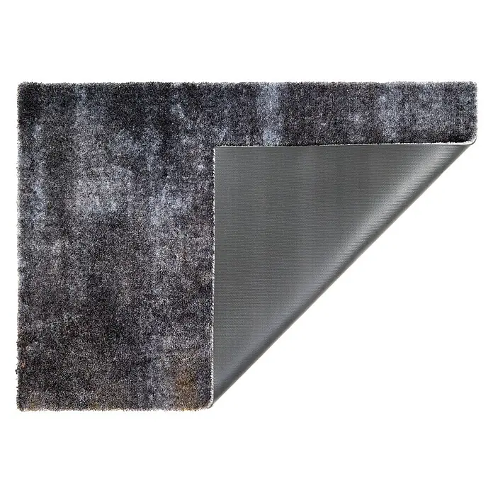 Fußmatte Manhattan - 100 x 67 cm, Anthrazit, Material Nutzschicht: 100 % Polyamid, Beton - Grauer Teppich mit filziger Oberseite, teilweise angehoben, um die strukturierte rutschfeste Unterseite zu zeigen.