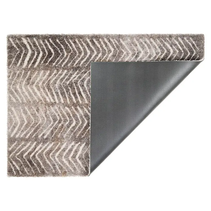 Fußmatte Manhattan - 70 x 50 cm, Taupe, Material Nutzschicht: 100 % Polyamid, Triangle - Grau-weißer Chevron-Teppich, teilweise umgeschlagen, zeigt die graue rutschfeste Unterseite.