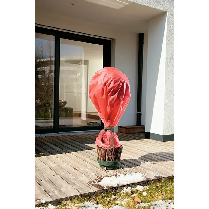 Windhager Winterschutzvlies - L x B: 10 x 1,6 m, Rot, Grammatur: 30 g/m² - Roter Stoff-Pflanzenschutzbezug für den Winter, mit grünem Band über einer Topfpflanze befestigt.