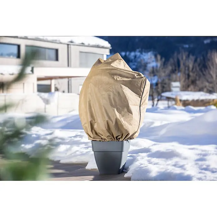 Windhager Winterschutzvlies - B x H: 110 x 110 cm, Beige, 50 g/m² - Hellerbrauner Pflanzenschutzbeutel auf einem dunkelgrauen Topf, schützt eine Pflanze im Schnee.