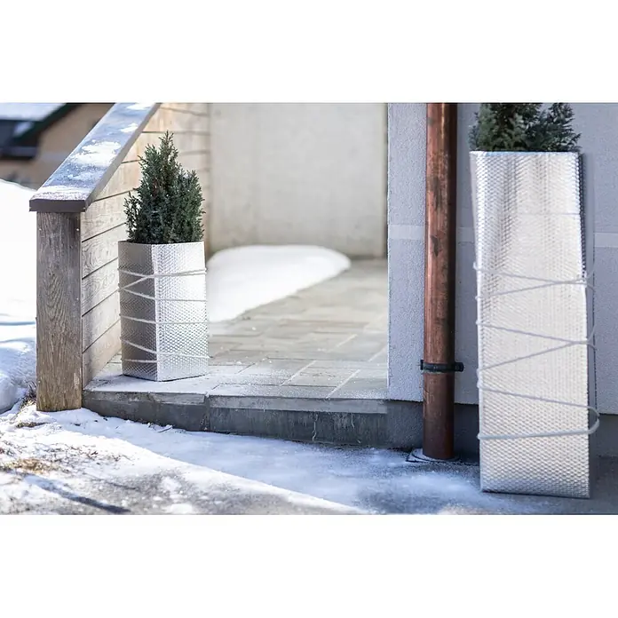 Windhager Kälteschutz - Garten, B x L: 50 x 500 cm, Silber - Zwei silberne, texturierte rechteckige Pflanzkübel mit immergrünen Pflanzen, mit weißer Schnur gebunden, draußen im Schnee.