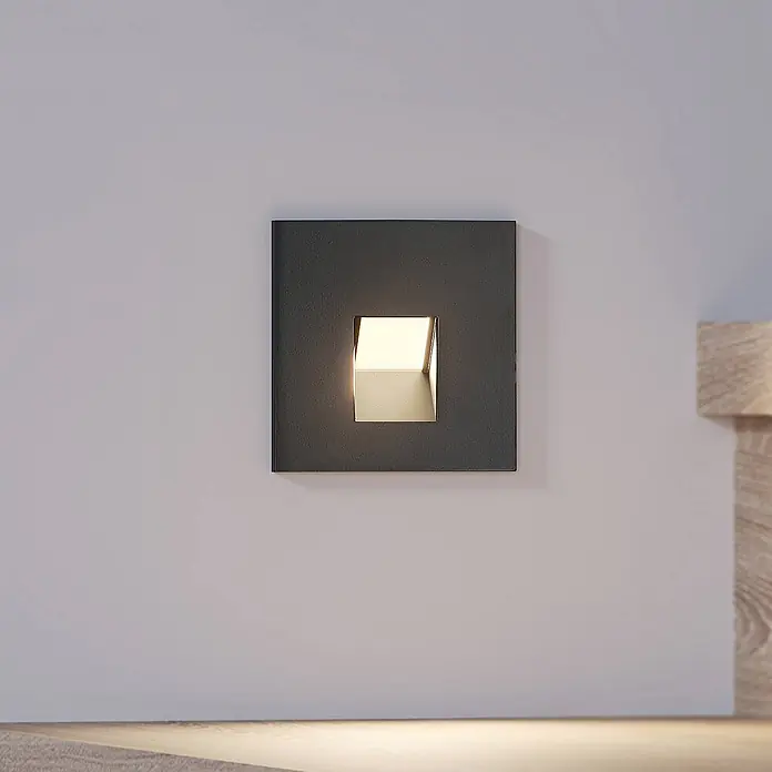 Arcchio Wandleuchte Vexi - schwarz - Quadratische, dunkelgraue Wandleuchte mit vertiefter Öffnung, die warmes Licht nach unten wirft, um eine Fläche zu beleuchten.