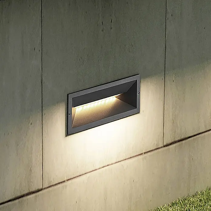 Lucande Außenwandleuchte Jaano - schwarz, IP65 - Rechteckige dunkelgraue LED-Einbauleuchte in Betonwand, strahlt warmes Licht nach unten.