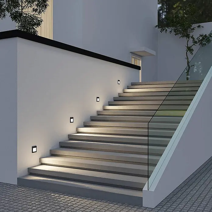 Arcchio Außenwandleuchte Zamo - schwarz, IP65 - Quadratische schwarze Außenstufenleuchten in weißer Wand, beleuchten Betontreppen.