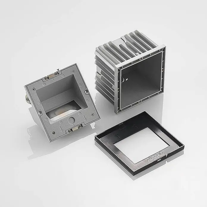 Arcchio Außenwandleuchte Zamo - schwarz, IP65 - Zerlegtes graues Aluminium-Außenleuchtengehäuse mit Kühlrippen und einer separaten schwarzen Blende.