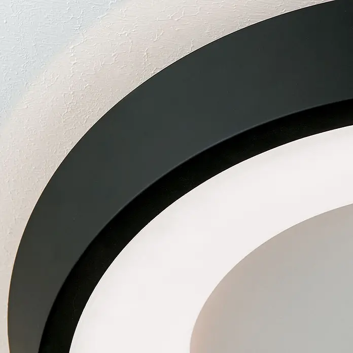 Orion Leuchten LED-Deckenleuchte rund -  - Runde schwarze Leuchte mit beleuchtetem weißen Innenbereich.