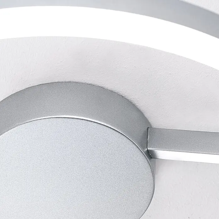 Orion Leuchten LED-Deckenleuchte rund -  - Nahaufnahme einer silberfarbenen Deckenleuchte mit rundem Sockel und gebogenem, beleuchtetem Streifen.